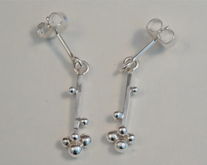 Zilveren oorbellen met bewegend staafje met zilveren balletjes. Op voorraad €65,00