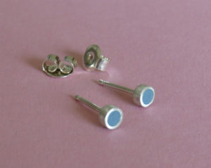 Zilveren oorbelknopjes gevuld met grijs/blauw kunststof. Op voorraad €30,00